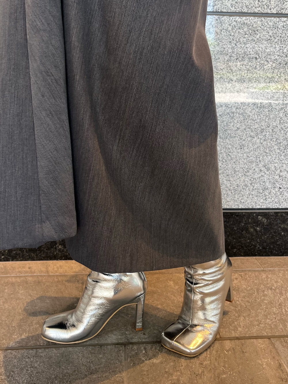 グレー系のジャンパースカート、シルバー系のブーツ、ゴールド系のハンドバッグを着用したレディースの夏コーディネートの10枚目の写真