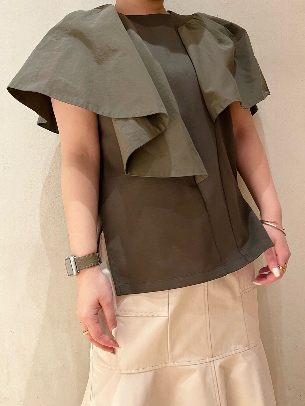 グリーン系のTシャツ/カットソー、ベージュ系のスカート、その他のサンダルを着用したレディースの春コーディネートの5枚目の写真