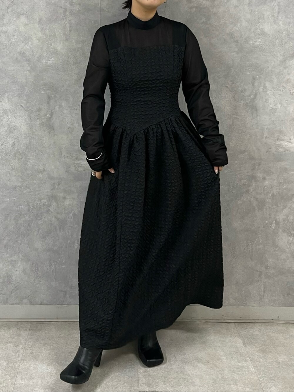 ブラック系のワンピース、ブラック系のブーツを着用したレディースの秋コーディネートの2枚目の写真