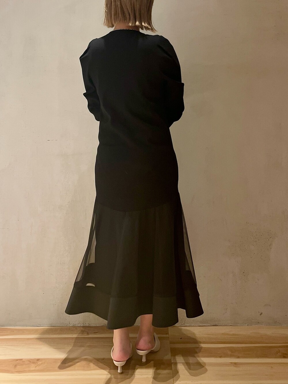 ブラック系のテーラードジャケット、ブラック系のワンピース、シルバー系のネックレスを着用したレディースの冬コーディネートの6枚目の写真