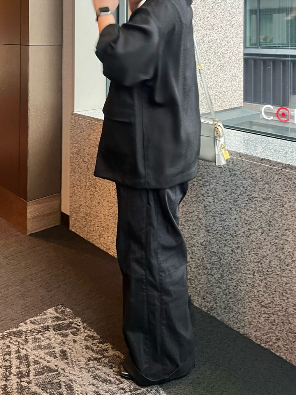 ブラック系のテーラードジャケット、ブラック系のその他パンツを着用したレディースの夏コーディネートの6枚目の写真