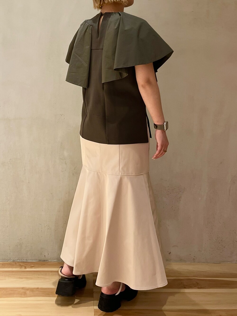 グリーン系のTシャツ/カットソー、ベージュ系のスカート、その他のサンダルを着用したレディースの春コーディネートの2枚目の写真