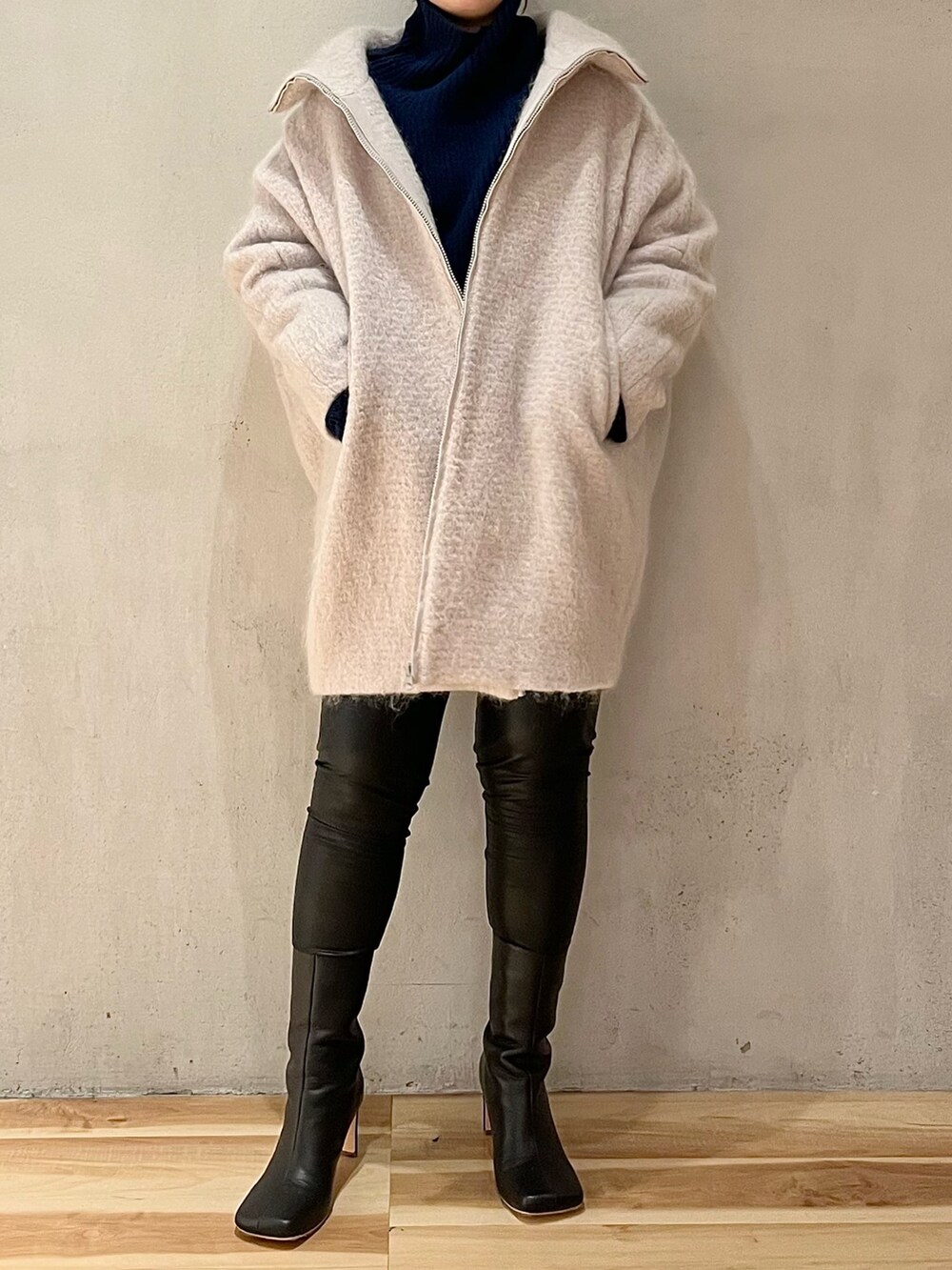ベージュ系のその他アウター、ブルー系のニット/セーター、ブラック系のその他パンツを着用したレディースの秋コーディネートの3枚目の写真