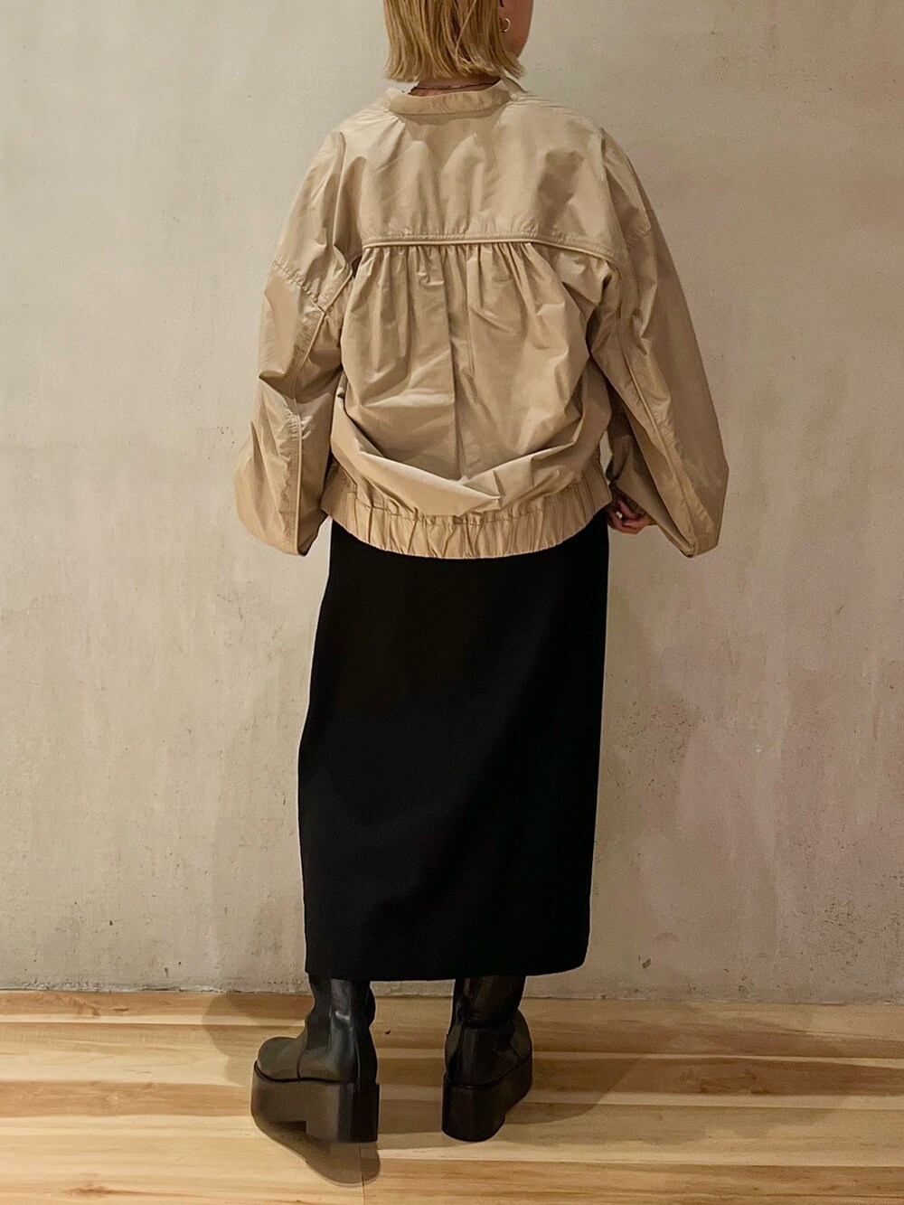 ベージュ系のブルゾン、ブラック系のスカート、ブラック系のブーツを着用したレディースの秋コーディネートの5枚目の写真