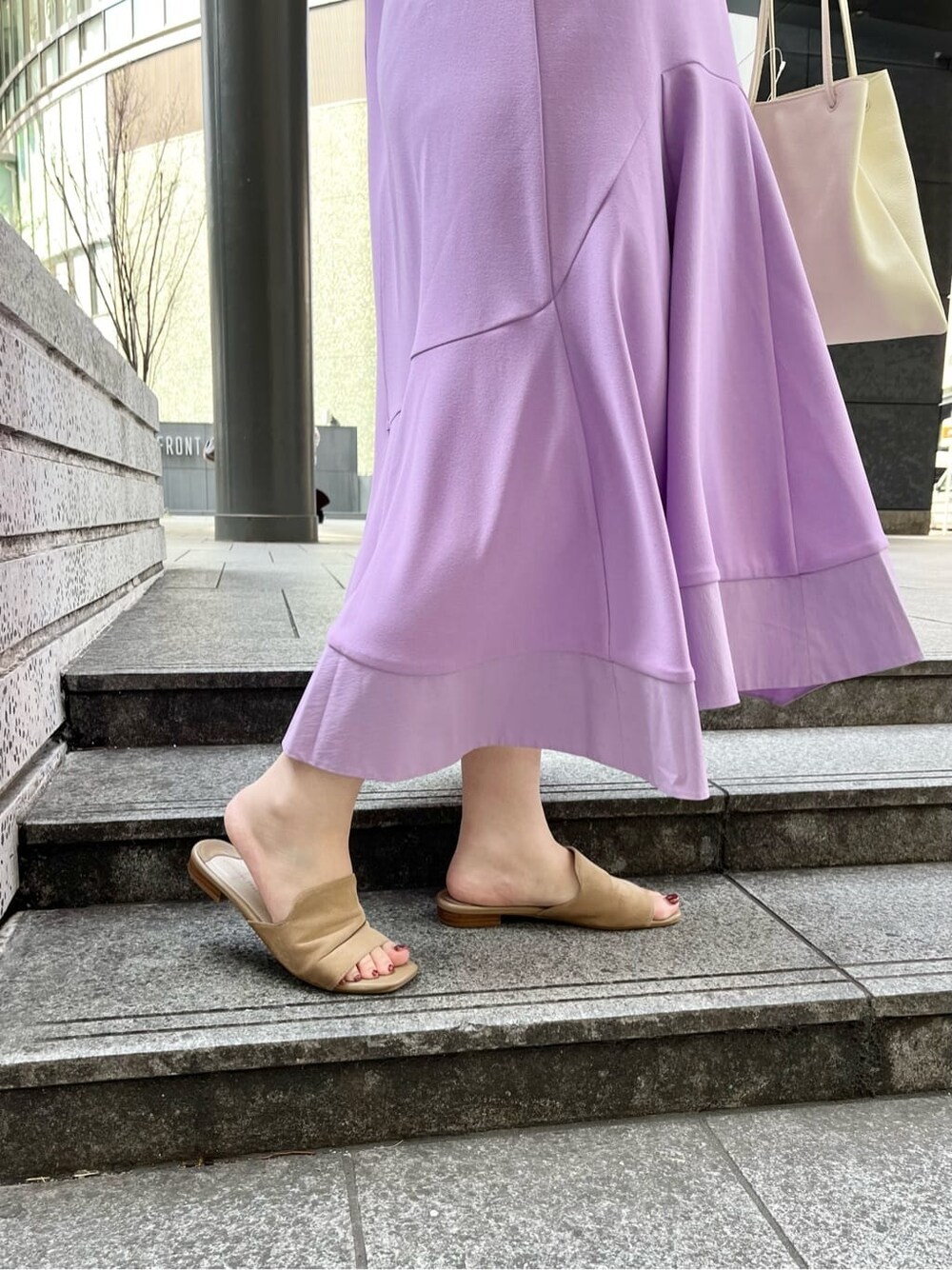 パープル系のワンピース、ホワイト系のハンドバッグを着用したレディースの春コーディネートの4枚目の写真