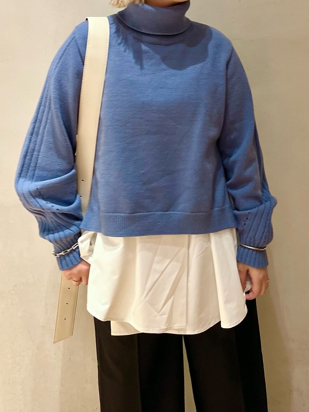ベージュ系のショルダーバッグ、ブルー系のニット/セーター、ブラック系のブーツを着用したレディースの秋コーディネートの5枚目の写真