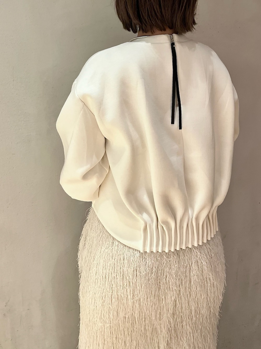 ホワイト系のTシャツ/カットソー、ホワイト系のスカート、ホワイト系のブーツを着用したレディースの春コーディネートの5枚目の写真