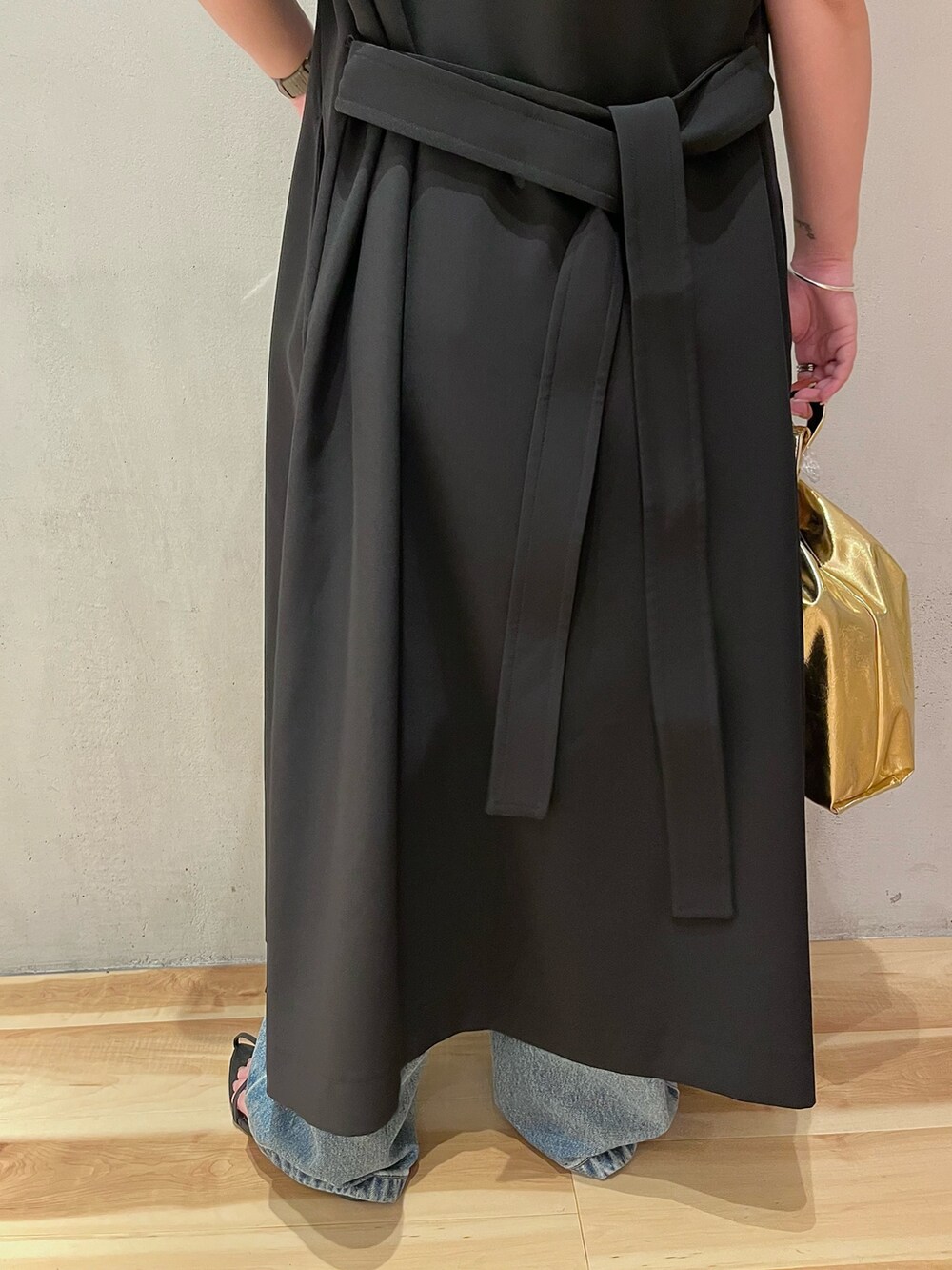 ブラック系のベスト、ブラウン系のタンクトップ、ブルー系のデニムパンツを着用したレディースの夏コーディネートの9枚目の写真