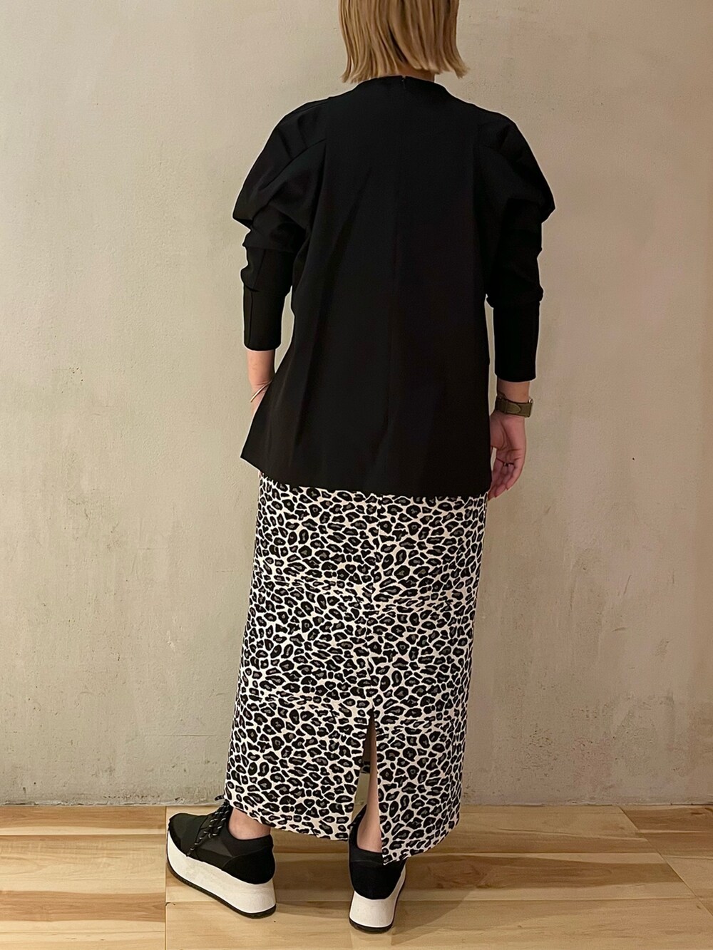 ブラック系のTシャツ/カットソー、ホワイト系のスカート、ブラック系のスニーカーを着用したレディースの春コーディネートの3枚目の写真