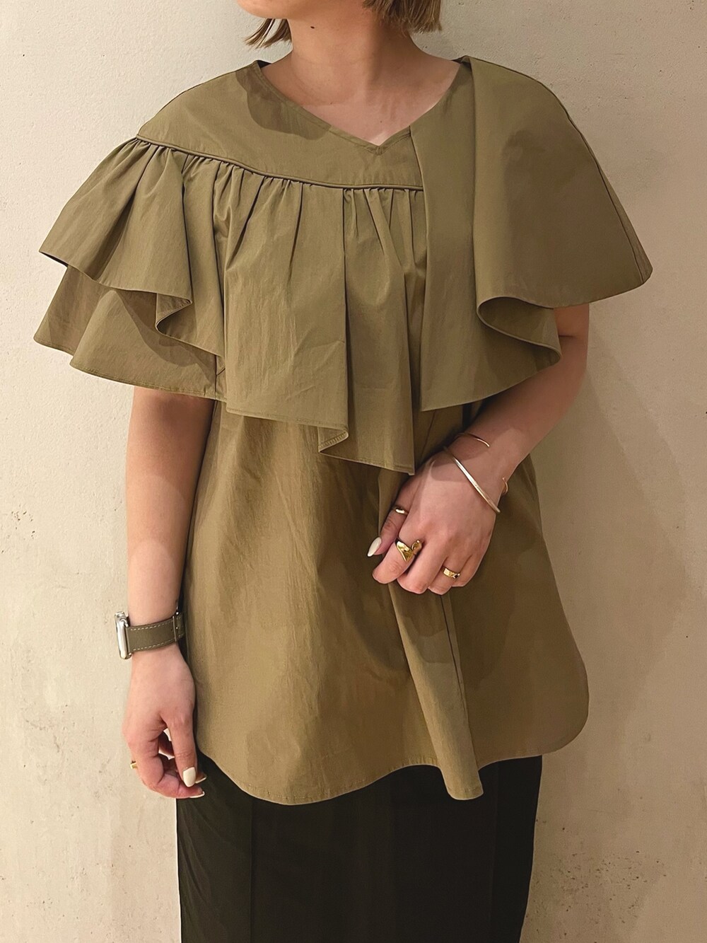 グリーン系のシャツ/ブラウス、ブラック系のスカート、ブラック系のサンダルを着用したレディースの冬コーディネートの5枚目の写真