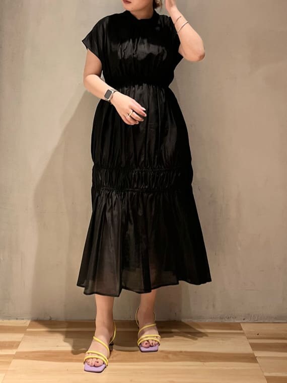 パープル系のサンダル、ブラック系のワンピースを着用したレディースの夏コーディネートの2枚目の写真