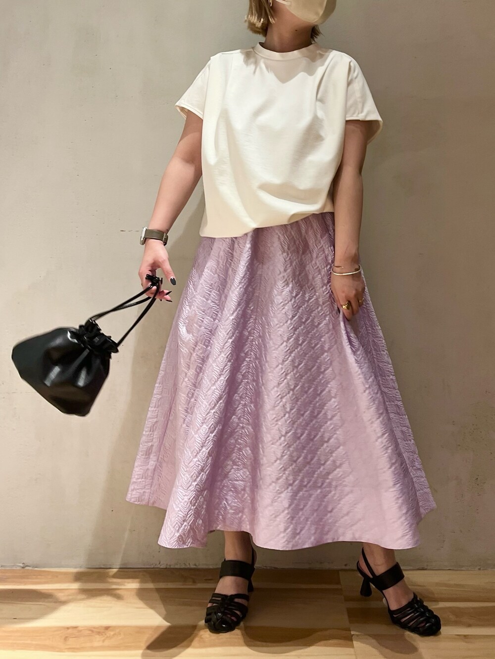 ホワイト系のTシャツ/カットソー、パープル系のスカート、ブラック系のサンダルを着用したレディースの春コーディネートの4枚目の写真