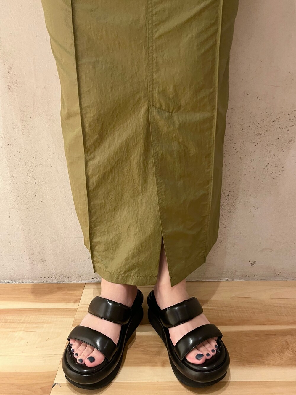 ホワイト系のTシャツ/カットソー、グリーン系のスカート、ブラック系のサンダルを着用したレディースの春コーディネートの9枚目の写真