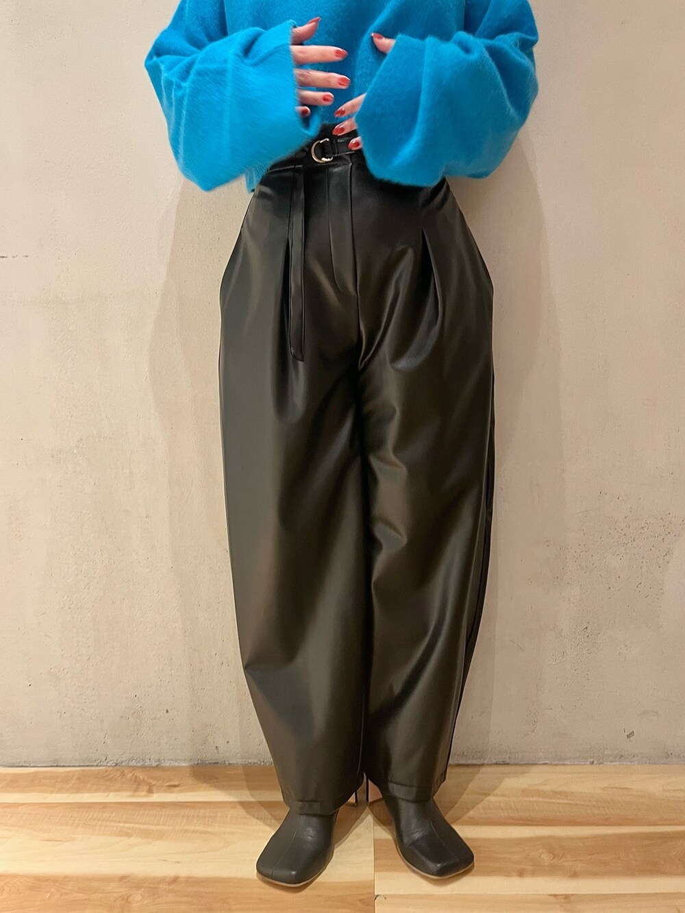 ブルー系のニット/セーター、ブラック系のその他パンツ、ブラック系のブーツを着用したレディースの秋コーディネートの8枚目の写真