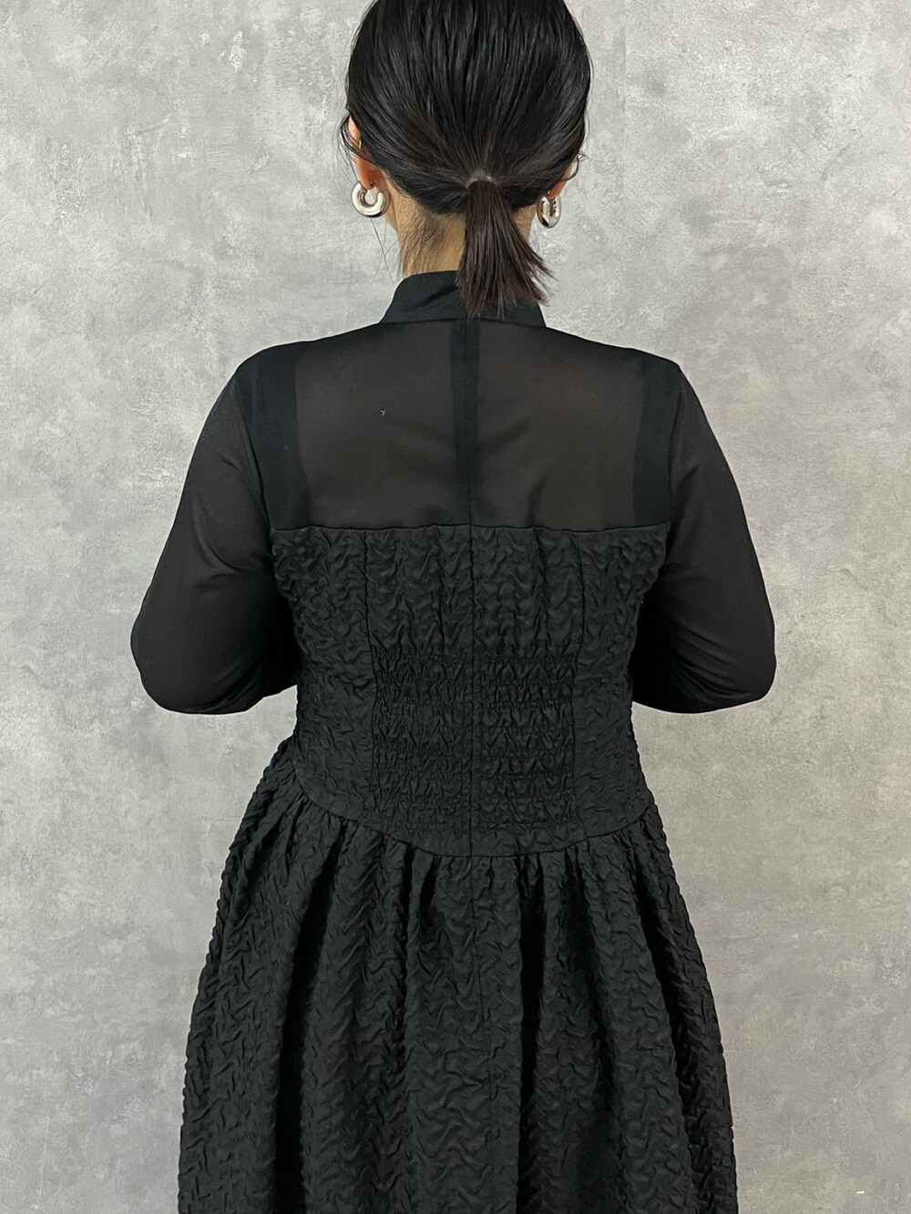 ブラック系のワンピース、ブラック系のブーツを着用したレディースの秋コーディネートの6枚目の写真