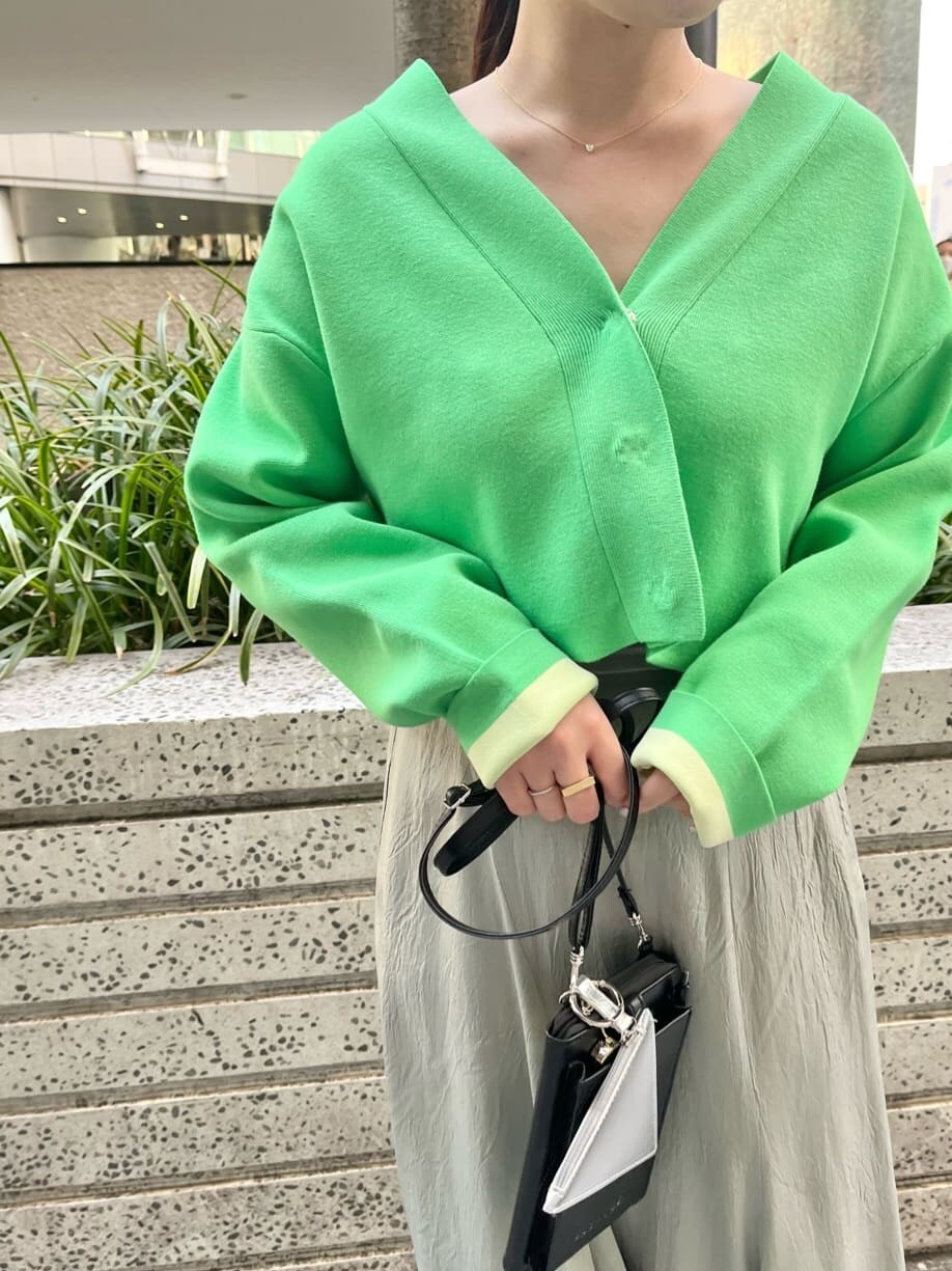 グリーン系のスニーカー、グリーン系のスカート、グリーン系のカーディガン/ボレロを着用したレディースの春コーディネートの5枚目の写真