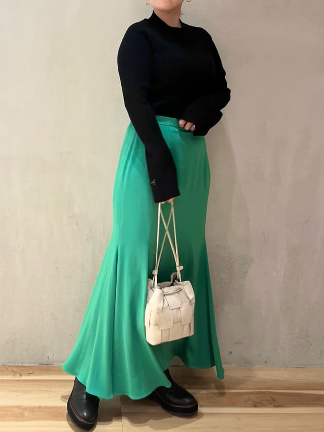 グリーン系のスカート、ベージュ系のノーカラーコート、ブラック系のニット/セーターを着用したレディースの秋コーディネートの8枚目の写真