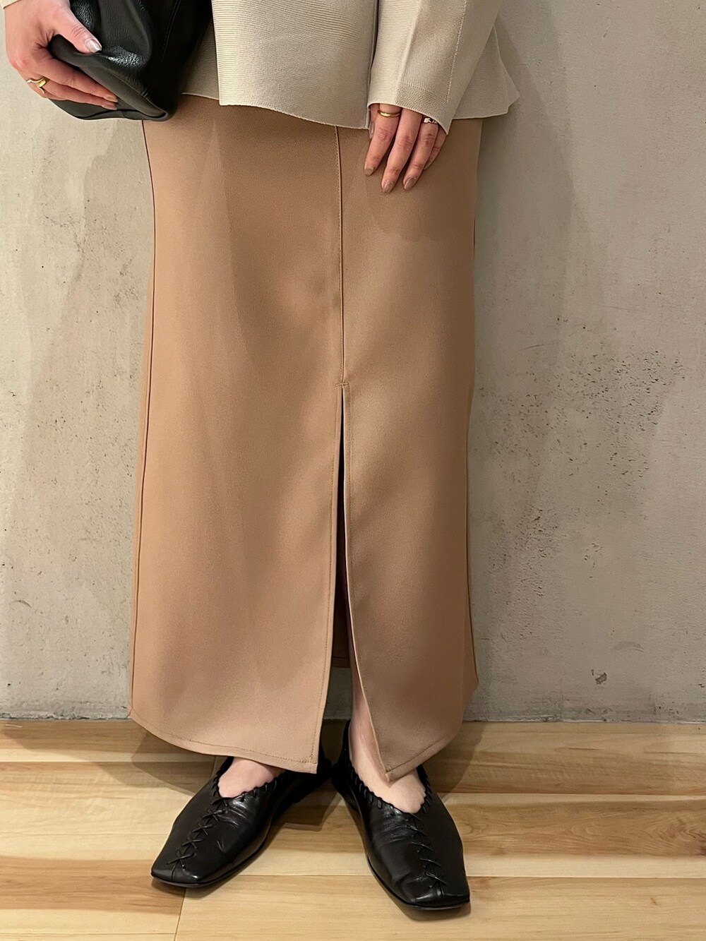 グレー系のニット/セーター、ベージュ系のスカートを着用したレディースの冬コーディネートの5枚目の写真