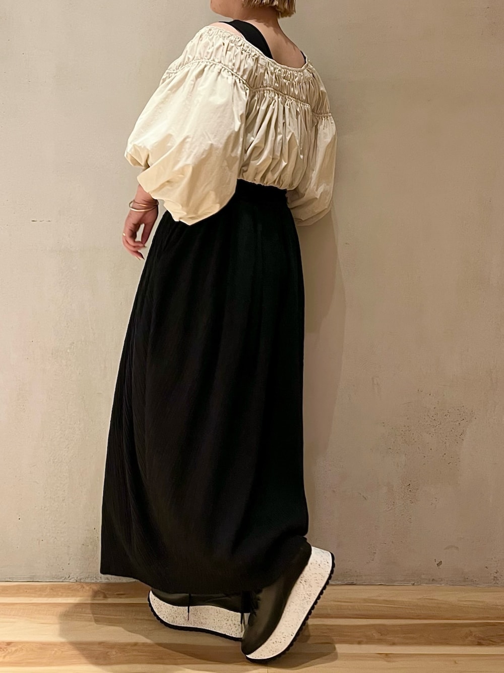 ブラック系のワンピース、ブラック系のスニーカーを着用したレディースの春コーディネートの2枚目の写真