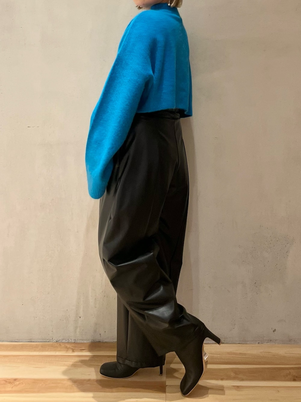 ブルー系のニット/セーター、ブラック系のその他パンツ、ブラック系のブーツを着用したレディースの秋コーディネートの2枚目の写真