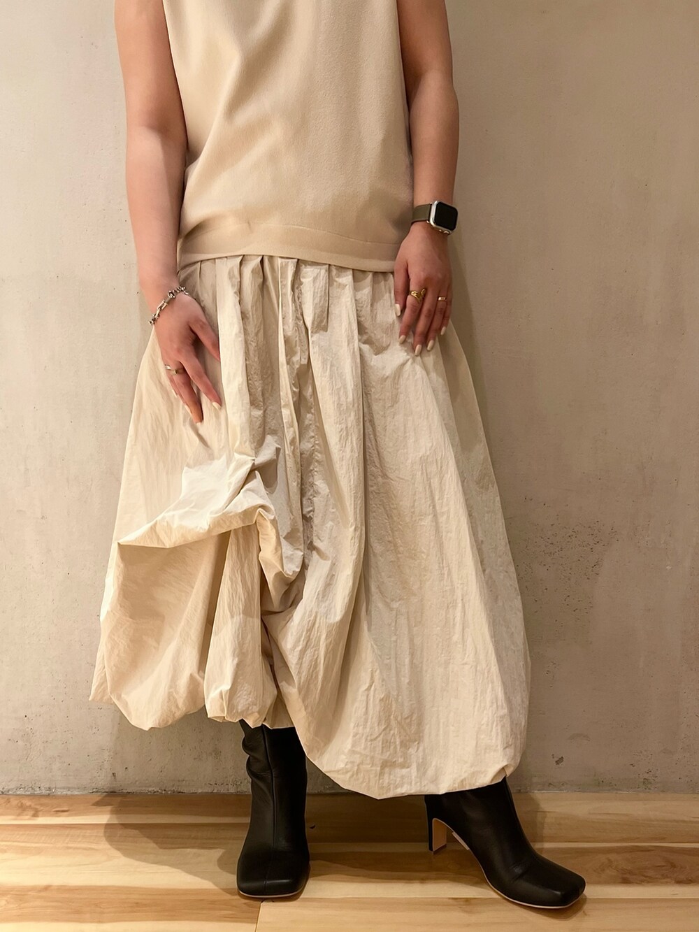 ベージュ系のノーカラージャケット、ベージュ系のワンピース、ブラック系のブーツを着用したレディースの夏コーディネートの8枚目の写真