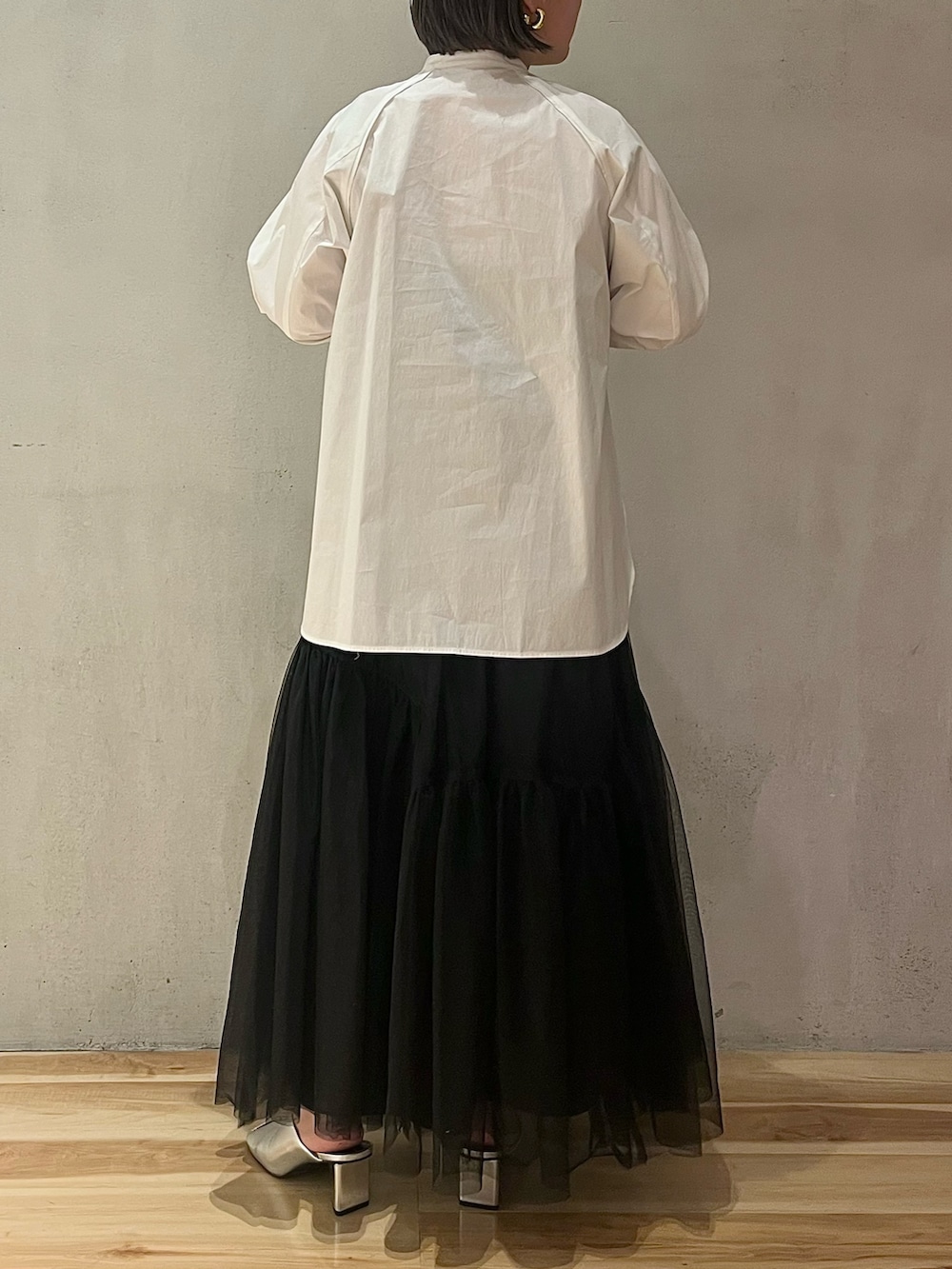 ブラック系のスカート、シルバー系のパンプス、ホワイト系のシャツ/ブラウスを着用したレディースの冬コーディネートの3枚目の写真