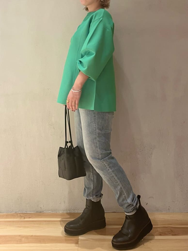 ブルー系のデニムパンツ、ブルー系のデニムパンツ、グリーン系のニット/セーターを着用したレディースの秋コーディネートの2枚目の写真