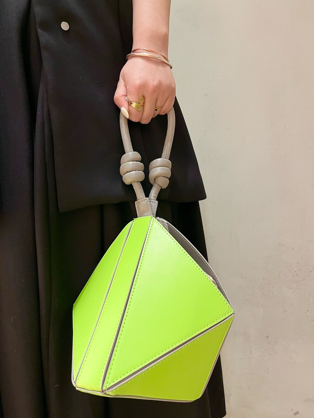 ブラック系のテーラードジャケット、ブラック系のワンピース、グリーン系のハンドバッグを着用したレディースの冬コーディネートの7枚目の写真