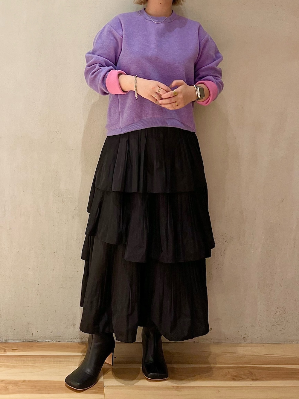 ホワイト系のダウンジャケット/コート、パープル系のニット/セーター、ブラック系のスカートを着用したレディースの夏コーディネートの7枚目の写真