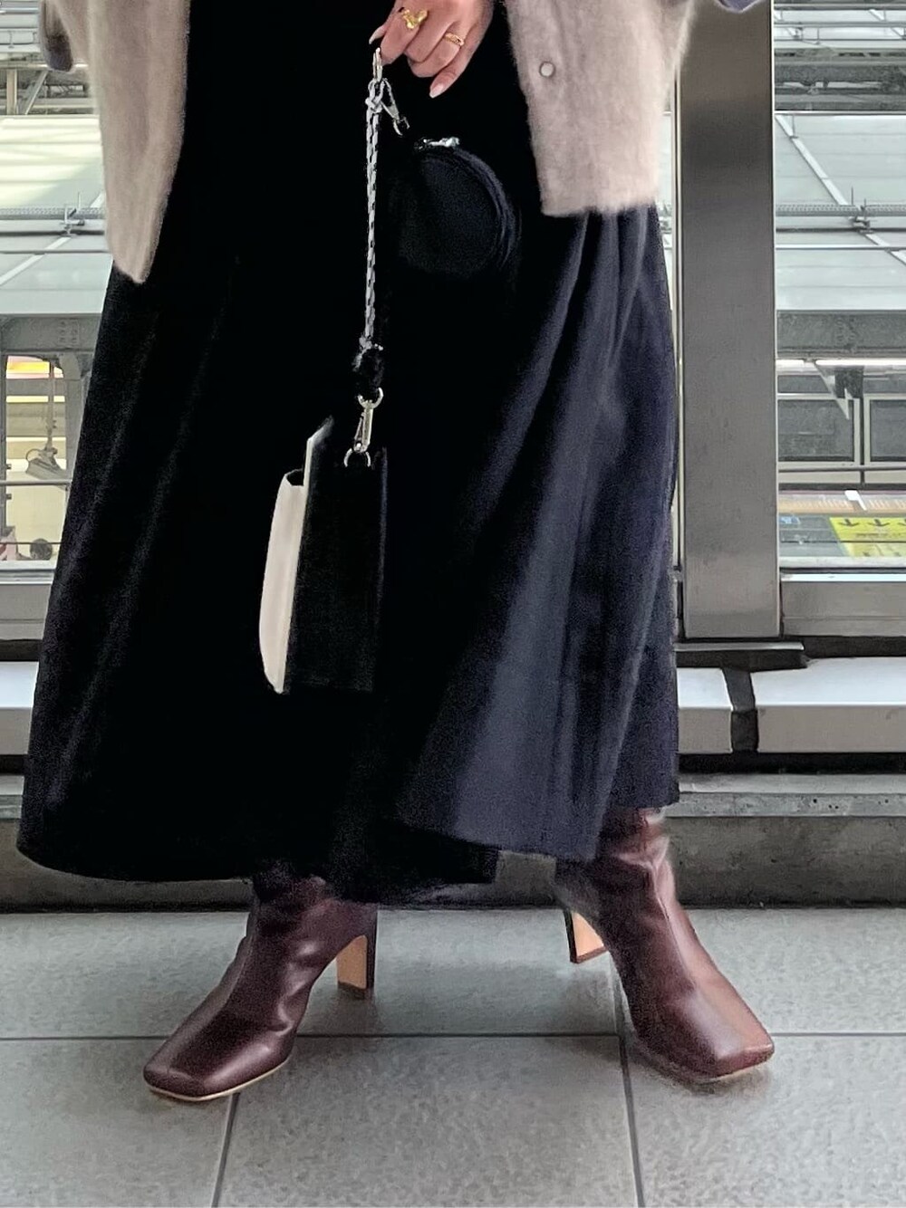 ブラック系のジャンパースカート、ホワイト系のショルダーバッグ、ベージュ系のシャツ/ブラウスを着用したレディースの夏コーディネートの8枚目の写真