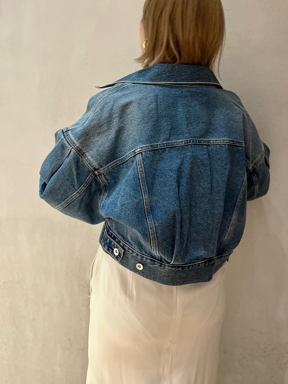 ブルー系のデニムジャケット、ホワイト系のワンピースを着用したレディースの冬コーディネートの6枚目の写真