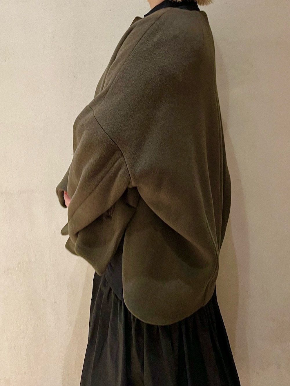 グリーン系のノーカラージャケット、ブラック系のワンピース、ブラック系のブーツを着用したレディースの秋コーディネートの5枚目の写真