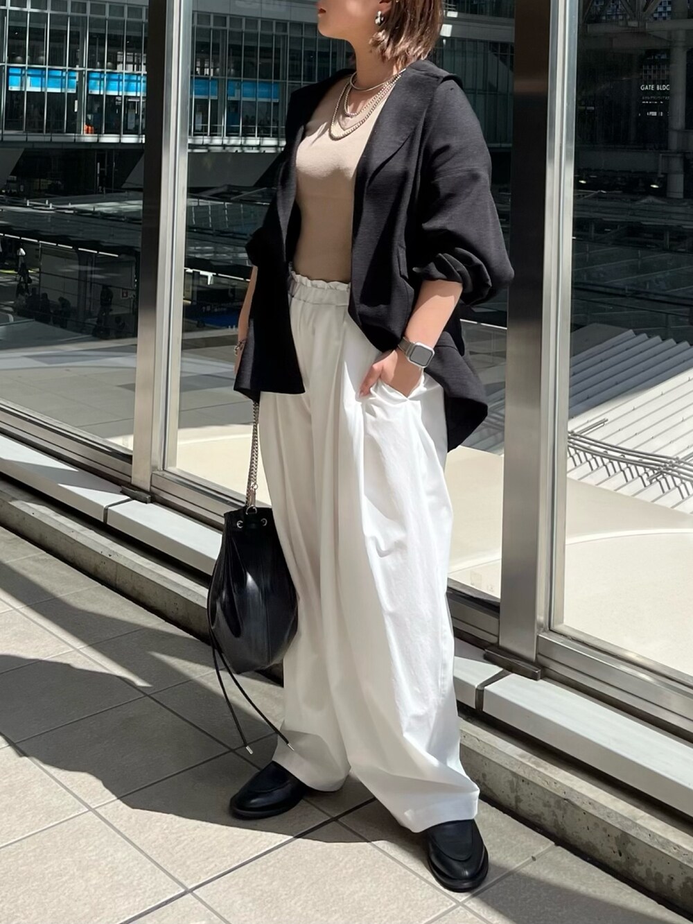 ブラック系のテーラードジャケット、ベージュ系のニット/セーター、ホワイト系のその他パンツを着用したレディースの春コーディネートの3枚目の写真