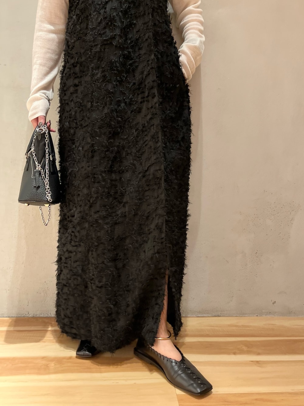 ブラック系のワンピース、ホワイト系のニット/セーターを着用したレディースの秋コーディネートの7枚目の写真