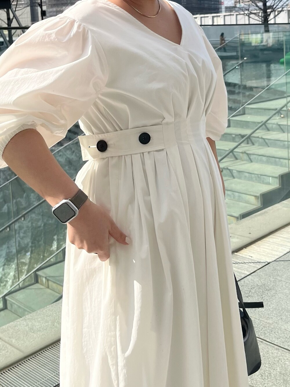 ブラック系のサンダル、ホワイト系のワンピース、ブラック系のハンドバッグを着用したレディースの冬コーディネートの5枚目の写真