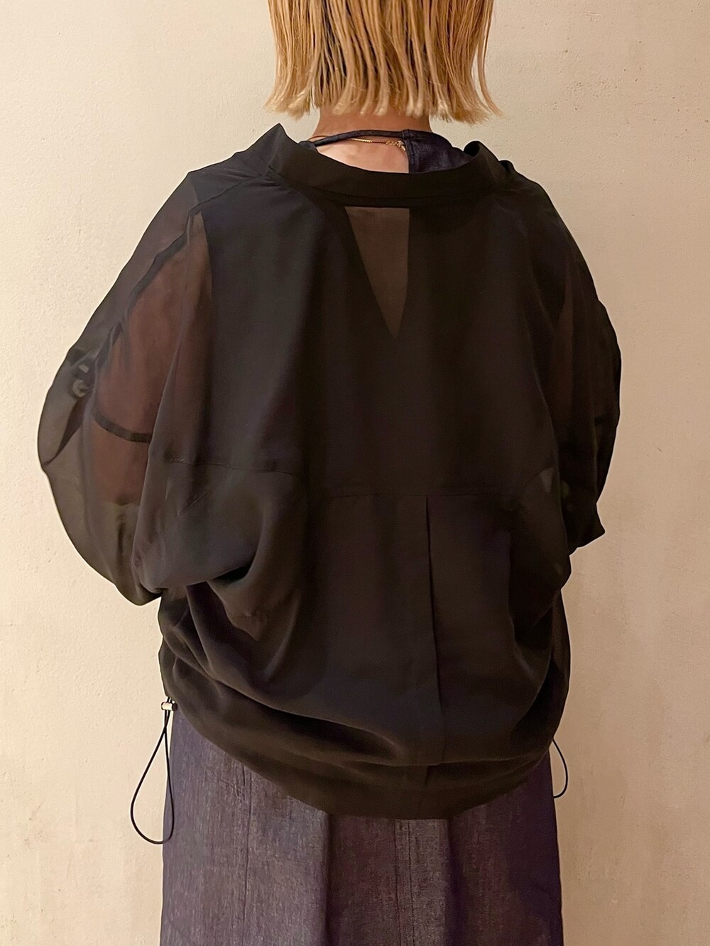 ブラック系のブルゾン、ブルー系のワンピース、ゴールド系のネックレスを着用したレディースの春コーディネートの6枚目の写真