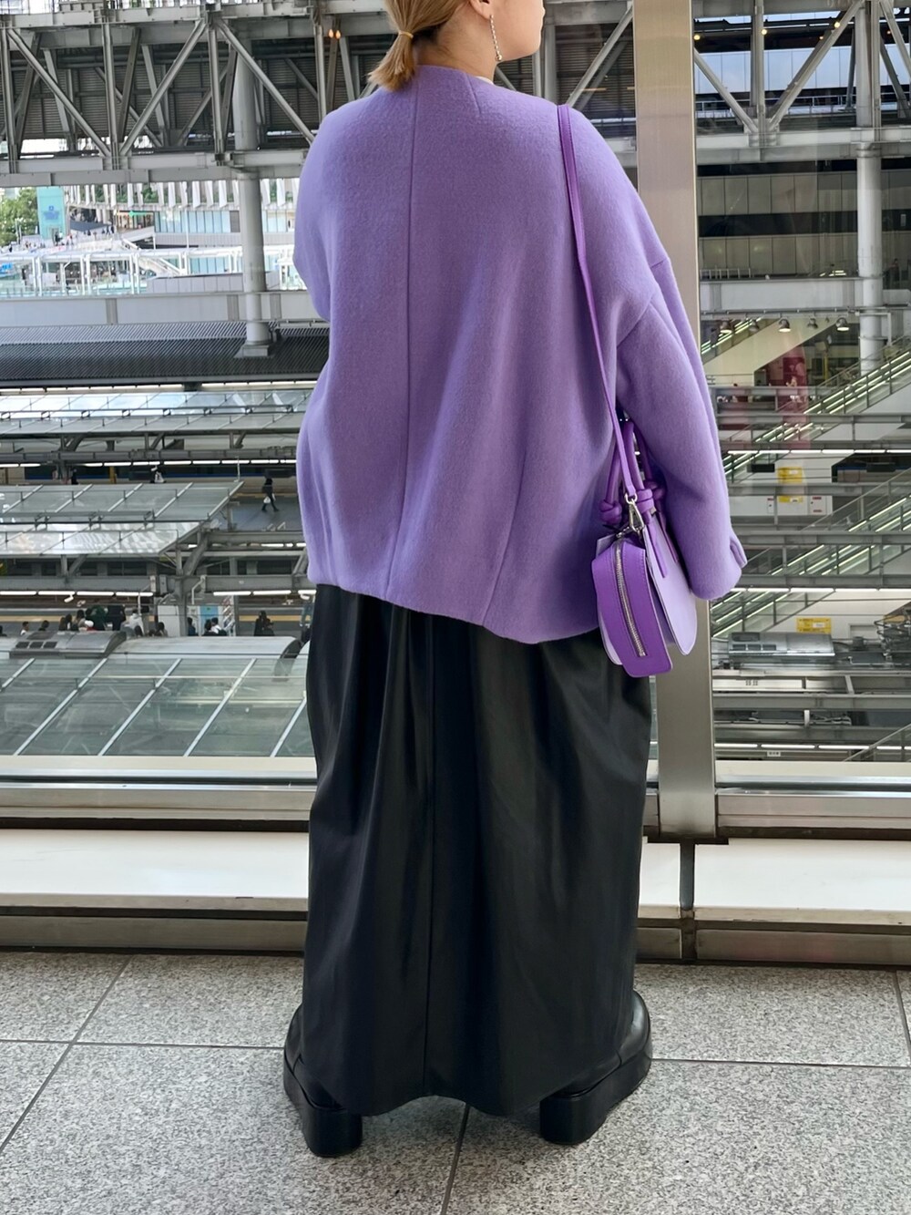 パープル系のノーカラージャケット、ブラック系のジャンパースカート、ホワイト系のニット/セーターを着用したレディースの秋コーディネートの3枚目の写真