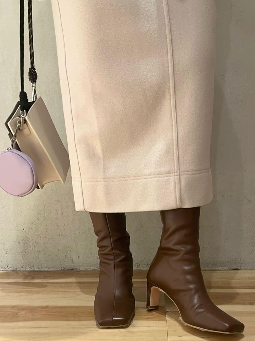 ブラウン系のブーツ、ベージュ系のショルダーバッグ、グリーン系のニット/セーターを着用したレディースの秋コーディネートの8枚目の写真