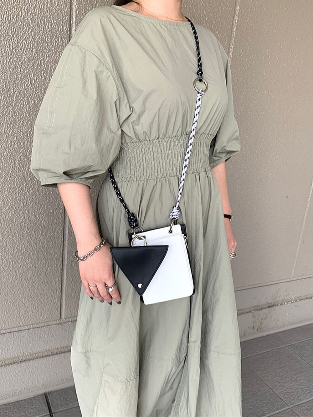 ブラック系のサンダル、グリーン系のワンピース、ブラック系のショルダーバッグを着用したレディースの夏コーディネートの3枚目の写真