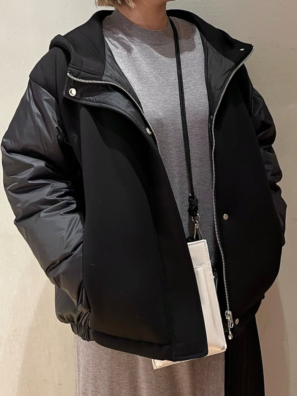 グレー系のワンピース、ホワイト系のスニーカー、ホワイト系のショルダーバッグを着用したレディースの冬コーディネートの4枚目の写真