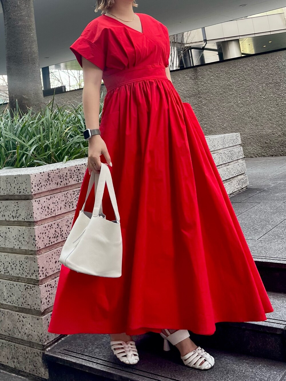 レッド系のワンピース、ホワイト系のハンドバッグ、ホワイト系のサンダルを着用したレディースの冬コーディネートの4枚目の写真