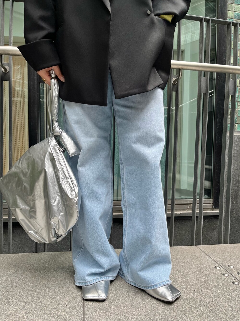 ブラック系のテーラードジャケット、イエロー系のニット/セーター、ブルー系のデニムパンツを着用したレディースの冬コーディネートの8枚目の写真