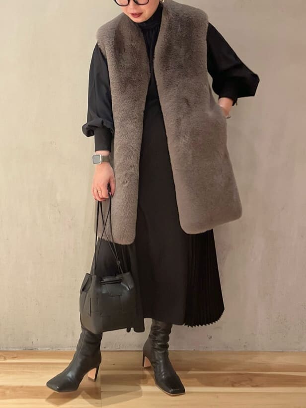 ブラック系のブーツ、ブラック系のワンピース、ブラウン系のその他アウターを着用したレディースの秋コーディネートの4枚目の写真