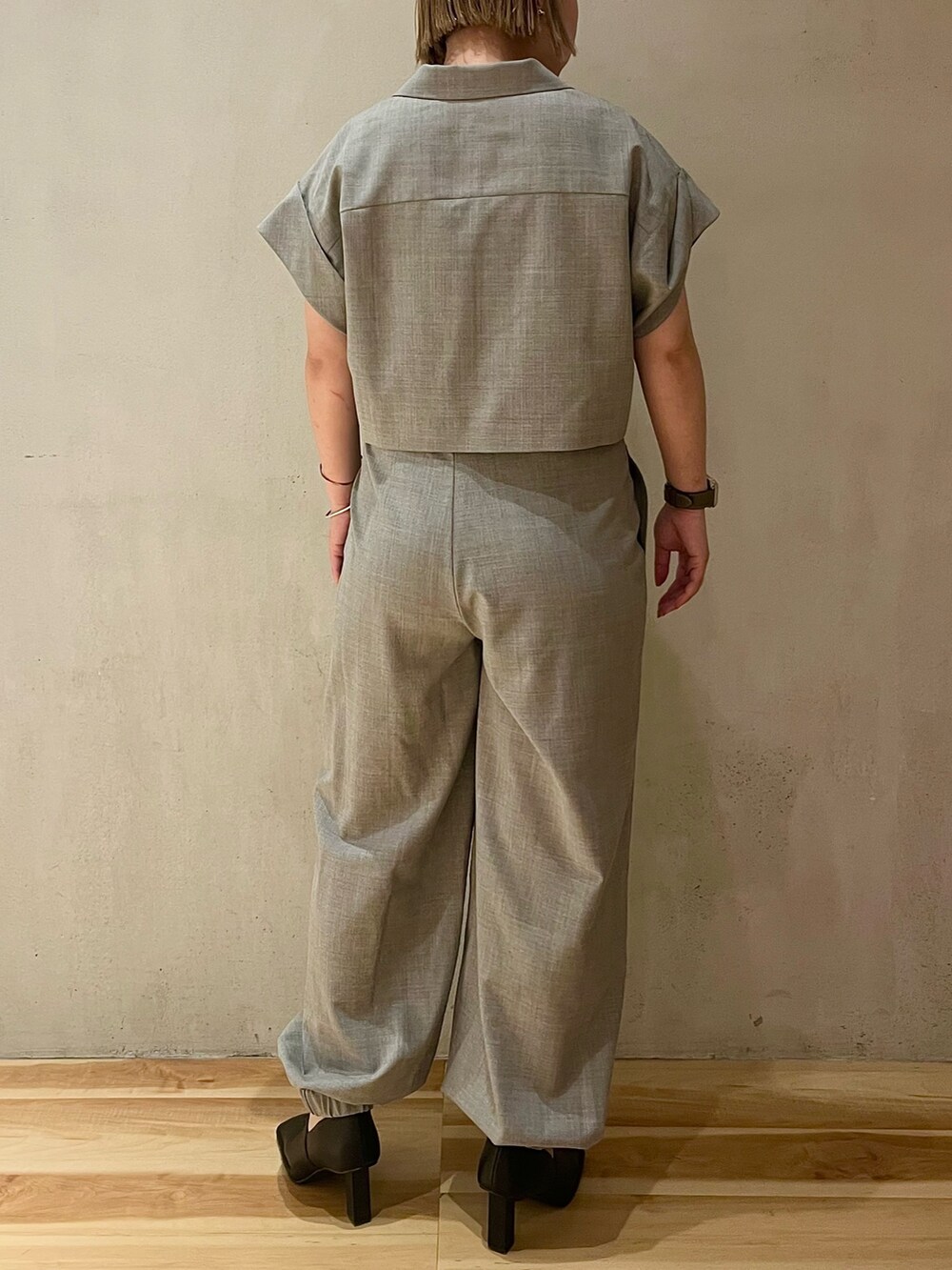 グレー系のテーラードジャケット、グレー系のスラックス、ブラック系のパンプスを着用したレディースの春コーディネートの3枚目の写真