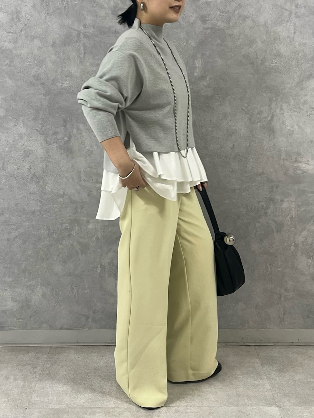 グレー系のノーカラージャケット、グレー系のニット/セーター、イエロー系のその他パンツを着用したレディースの秋コーディネートの8枚目の写真