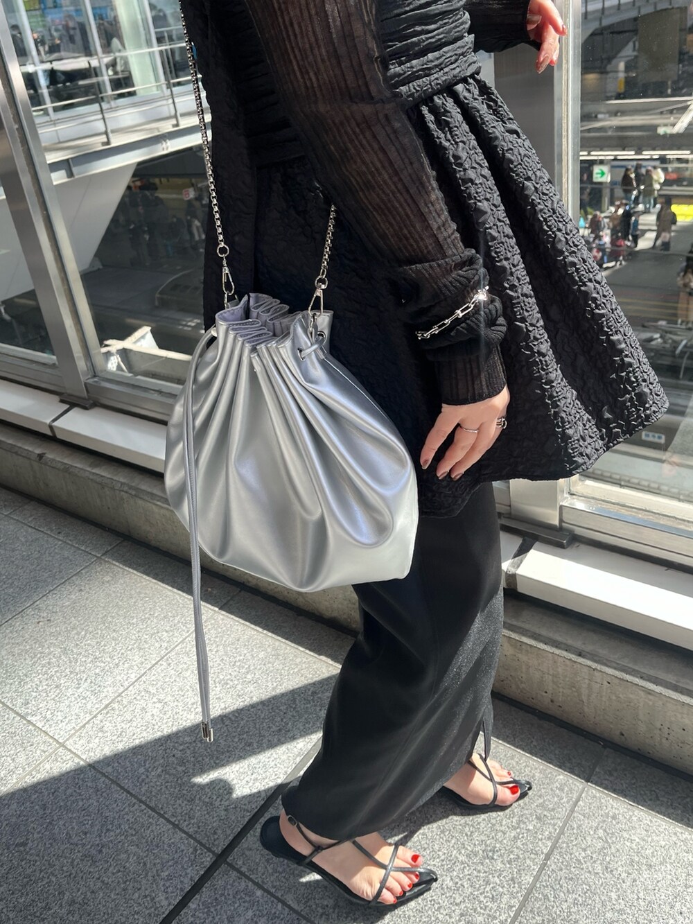 ブラック系のニット/セーター、ブラック系のシャツ/ブラウス、シルバー系のショルダーバッグを着用したレディースの春コーディネートの7枚目の写真