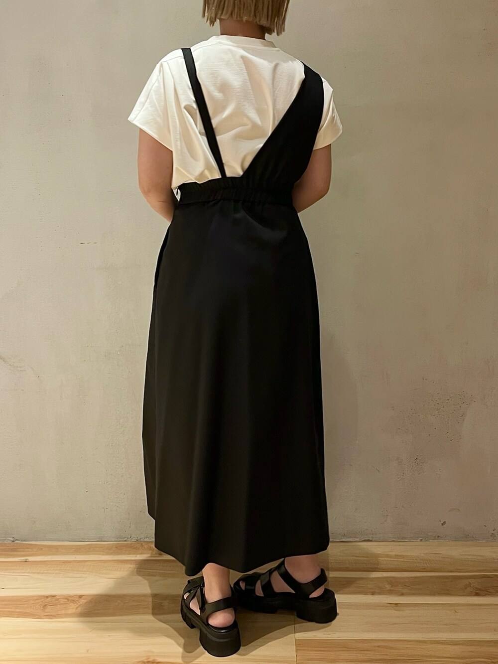 ホワイト系のTシャツ/カットソー、ブラック系のジャンパースカート、シルバー系のネックレスを着用したレディースの春コーディネートの4枚目の写真