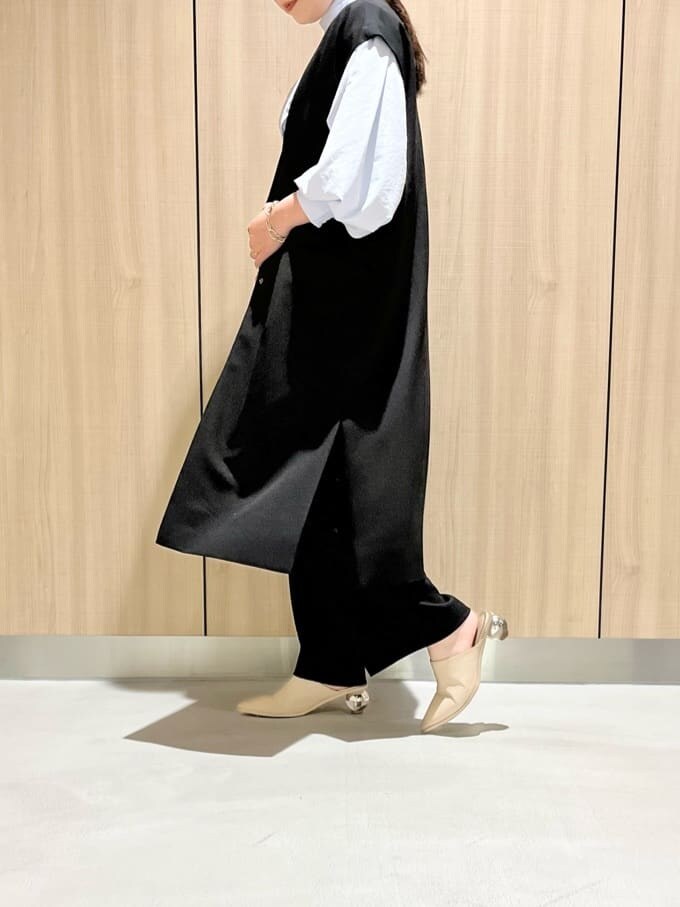 ブラック系のスラックス、ブラック系のノーカラージャケット、ブルー系のシャツ/ブラウスを着用したレディースの春コーディネートの3枚目の写真