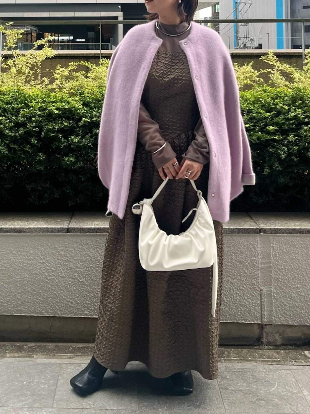 パープル系のカーディガン/ボレロ、ホワイト系のハンドバッグ、ベージュ系のワンピースを着用したレディースの夏コーディネートの3枚目の写真