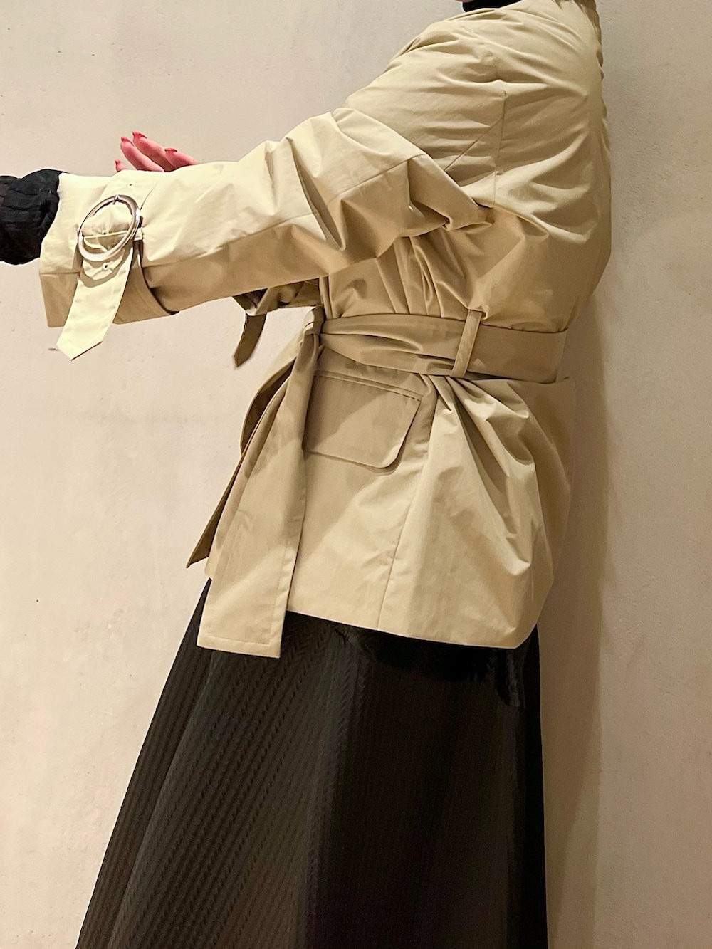 ベージュ系のノーカラージャケット、ブラック系のニット/セーター、ブラック系のスカートを着用したレディースの秋コーディネートの6枚目の写真